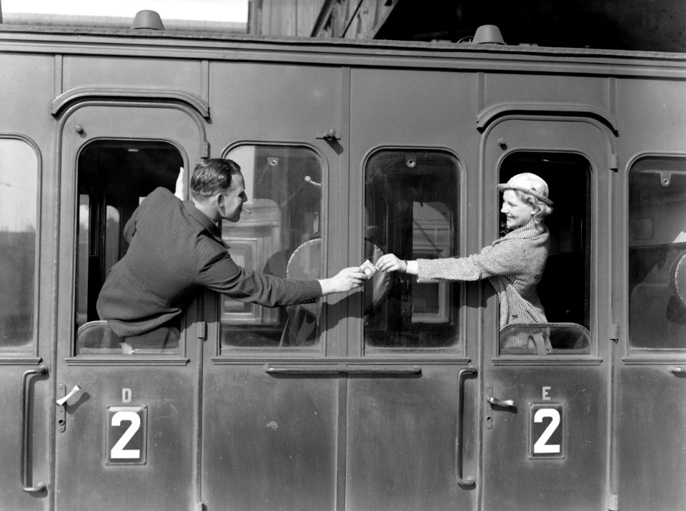 Een man reikt model Eva Waldschmidt een sigaret aan via de deur van een treincou, Bestanddeelnr 189-1266