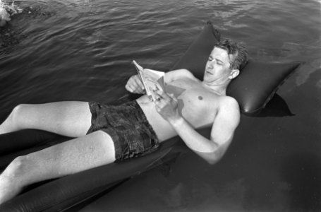 Een man op een luchtbed leest een boek, Bestanddeelnr 920-4559