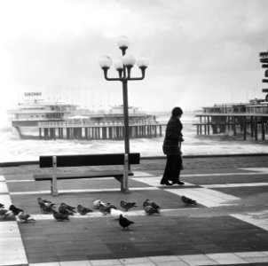 Een wandelaar op de boulevard, op de achtergrond de pier, Bestanddeelnr 926-8255