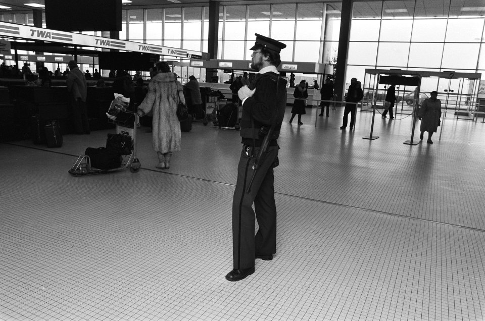 Een agent surveilleert in een van de hallen van Schiphol, Bestanddeelnr 933-5286