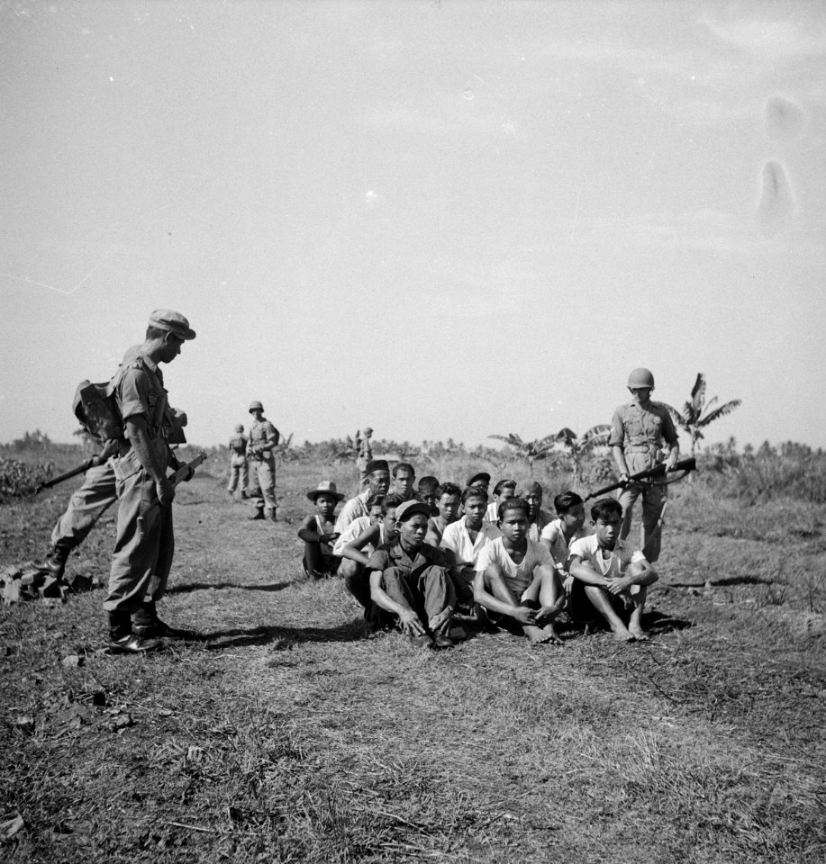 Een groep gevangenen zit op de grond, bewaakt door soldaten voorbeeld van goe…, Bestanddeelnr 15865