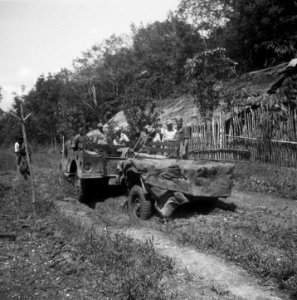 Een groep Nederlandse militairen bij een kampong. Op de voorgrond pickup-truck , Bestanddeelnr 8130