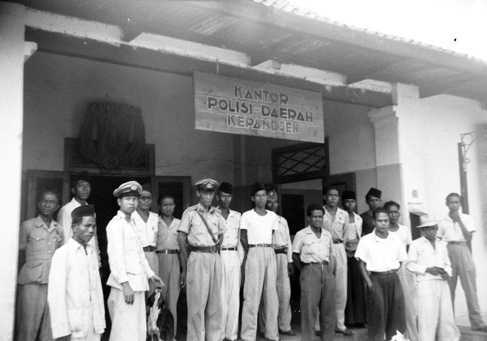 Een groep Indonesische mannen in burger en uniform poseren op de veranda van ee, Bestanddeelnr 15900