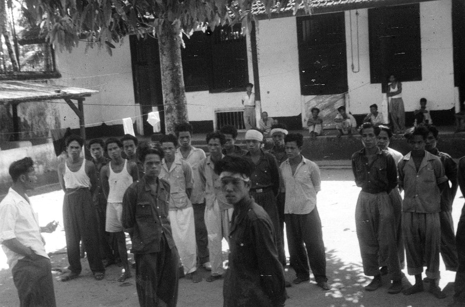 Een groep Indonesische man staat opgesteld met de handen op de rug. Sommigen dra, Bestanddeelnr 5368