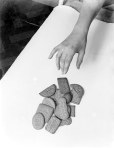 Een hand pakt een biscuitje van Verkade, Bestanddeelnr 252-0482