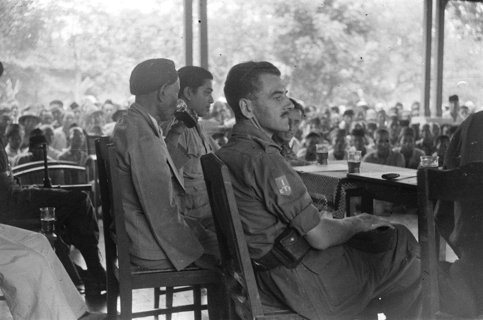 Een grote groep Indonesiërs op een veranda wordt toegesproken Achter een tafel , Bestanddeelnr 489-6-4