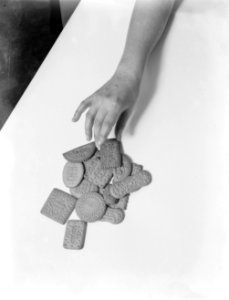 Een hand pakt een biscuitje van Verkade, Bestanddeelnr 252-0483