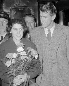 Edmund HIllary and wife with flowers in 1953 Amsterdam train station detail, from- Aankomst Hillary ( Mount Everest beklimmer) te Amsterdam, Bestanddeelnr 906-1044 (cropped)
