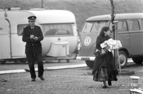 Een bewoners en een politieagent, met op de achtergrond een caravan en een busje, Bestanddeelnr 926-9295