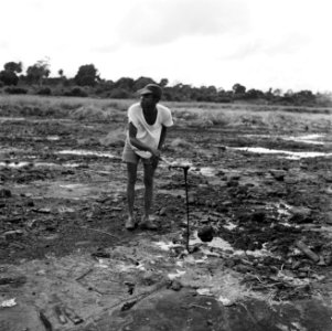 Een arbeider op een asfaltveld op Trinidad, Bestanddeelnr 252-5333