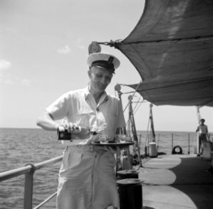 Een bemanningslid schenkt jenever in op Hr Ms Van Speijk, Bestanddeelnr 252-8514