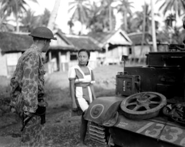 Een officier praat met een (modieus geklede) Indonesische vrouw, staand bij een, Bestanddeelnr 10553