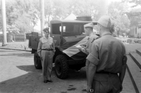 Een officier verlaat een gebouw terwijl hij een document leest Een vrachtwagen, Bestanddeelnr 54-1-5