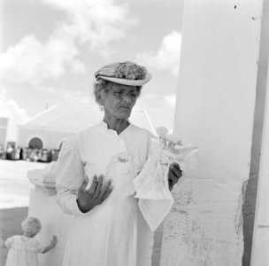 Een oude vrouw met bloemen bij de koninklijke ontvangst op Bonaire, Bestanddeelnr 252-3843