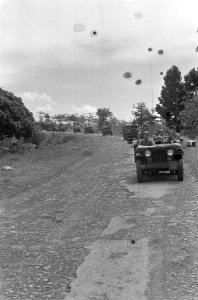 Een colonne trucks met militairen, voorafgegaan door een jeep rijdt over een la, Bestanddeelnr 4036