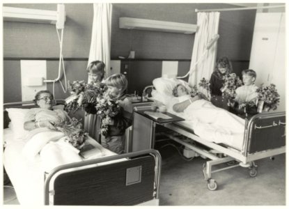 Een oude traditie in ere hersteld kinderen van de Fuhropschool brengen bloemen van de schooltuin aan patiënten van het St. Joannes de Deo-ziekenhuis. NL-HlmNHA 54016631