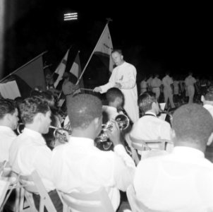 Een geestelijke, Frère Pedro, dirigeert een jeugdorkest in het Wilhelminastadion, Bestanddeelnr 252-3865