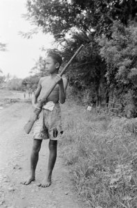 Een jonge Indonesische jongen poseert met een antiek geweer, Bestanddeelnr 466-6-8