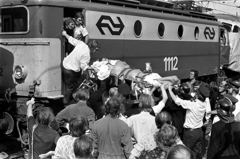 Een gewonde machinist wordt op een brancard uit de treinlocomotief gedragen, Bestanddeelnr 928-0900