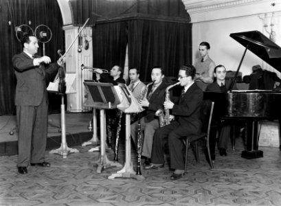 Een gezelschap van blazers, een violist en een pianist bij een repetitie, Bestanddeelnr 252-1783