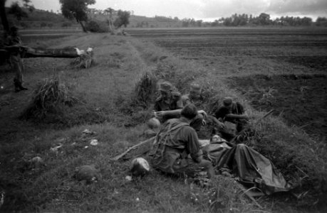Een gewonde militair ligt op een brancard en onder een zeil in een greppel, om , Bestanddeelnr 2732