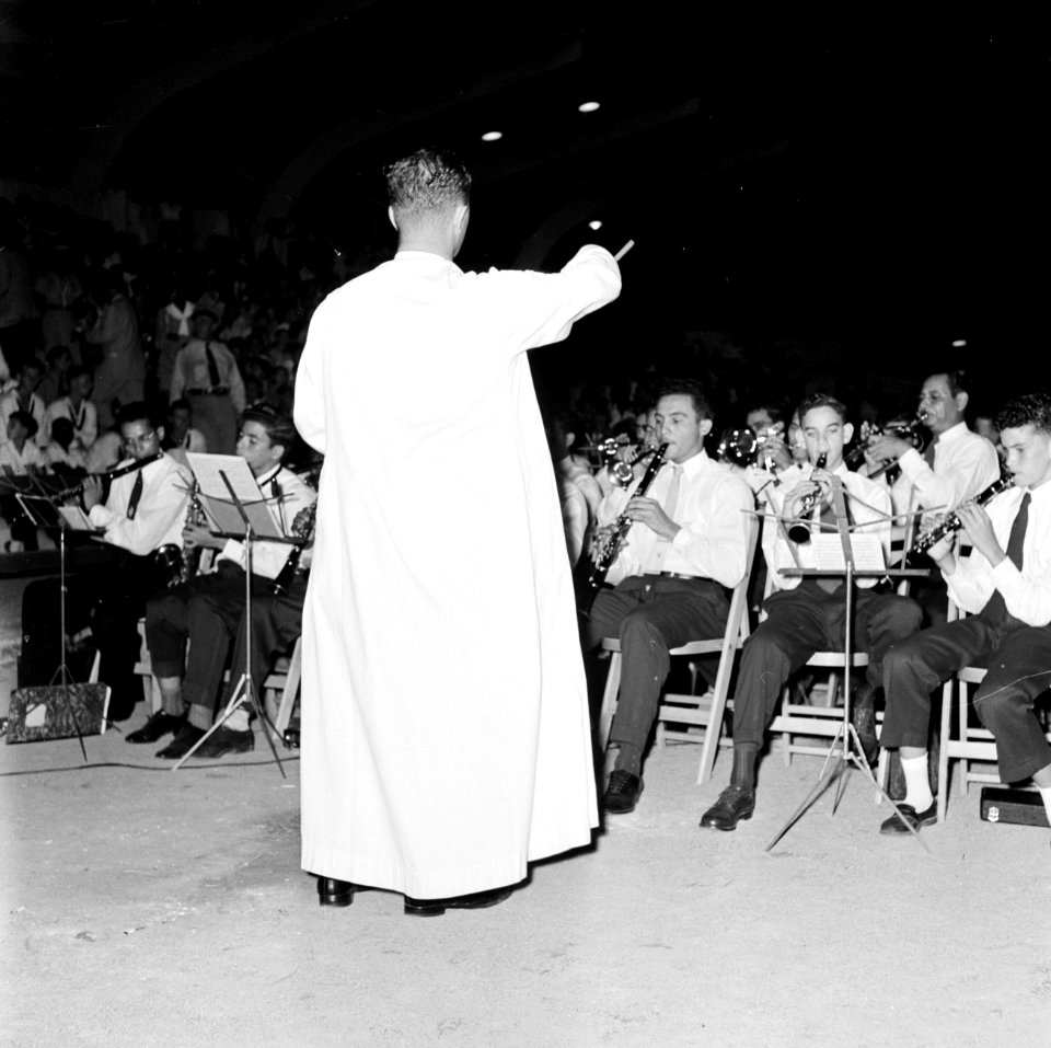 Een geestelijke, Frère Pedro, dirigeert een jeugdorkest in het Wilhelminastadion, Bestanddeelnr 252-3864
