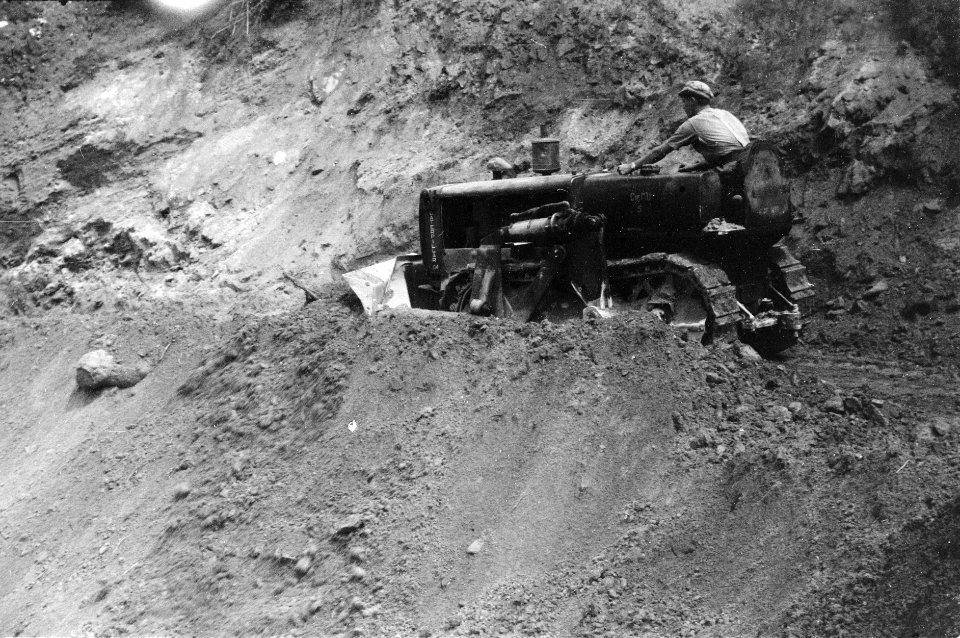 Een bulldozer bezig met het repareren van een weggedeelte, Bestanddeelnr 2742