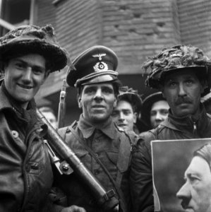Een Britse militair getooid met een Duitse officierspet een andere voert een po, Bestanddeelnr 900-2386