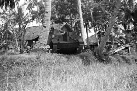 Een brencarrier genaamd Zwarte Duivel manoeuvreert in een kampong, terwijl aa, Bestanddeelnr 62-1-4