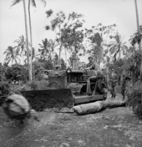 Een bulldozer verwijdert een boomstronk van een weg, Bestanddeelnr 14987