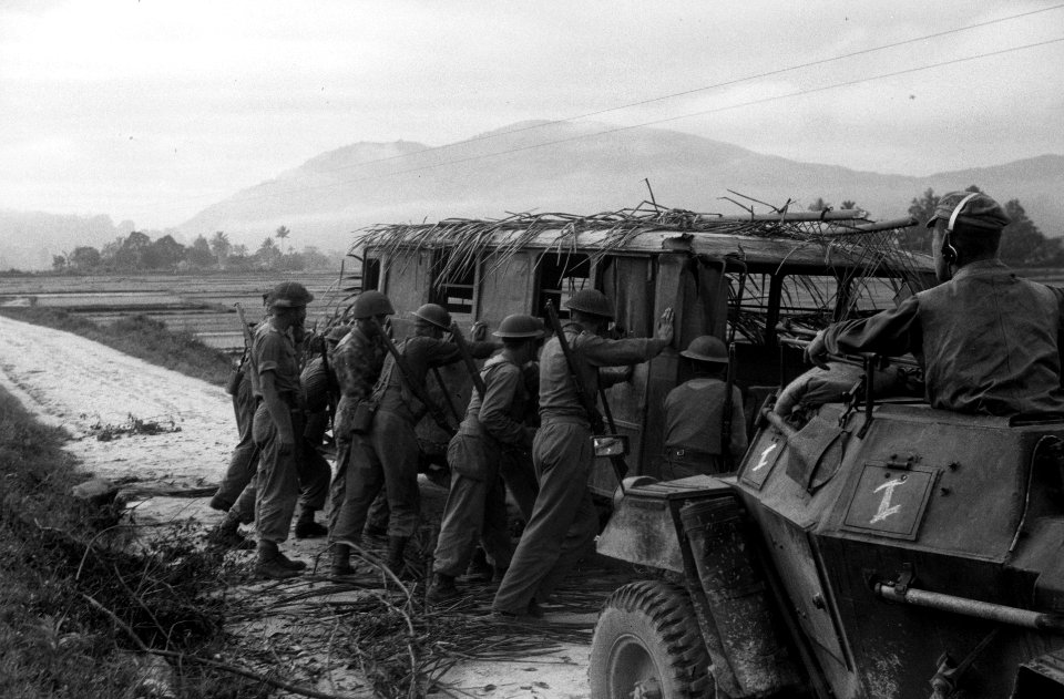 Een autobus zonder banden en met palmtakken op het dak, Nederlandse infanterist, Bestanddeelnr 2914