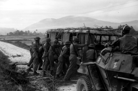 Een autobus zonder banden en met palmtakken op het dak, Nederlandse infanterist, Bestanddeelnr 2914
