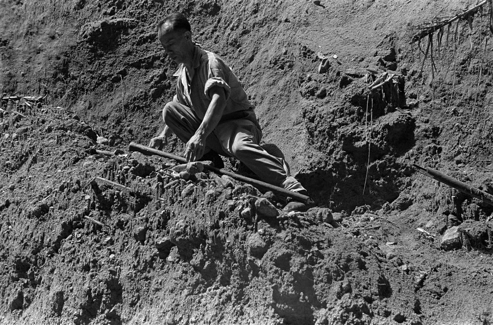 Een Chinees-Indische man met een staf op een zandheuvel in de kloof, Bestanddeelnr 3567