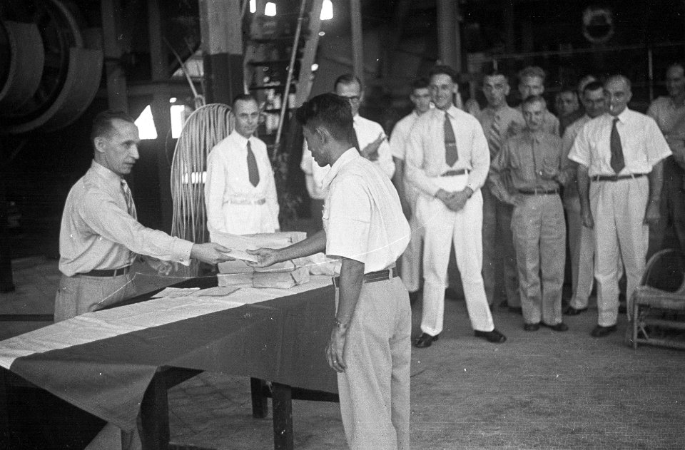 Een Indonesische man krijgt iets uitgereikt (een diploma) van een man in unifor, Bestanddeelnr 7096