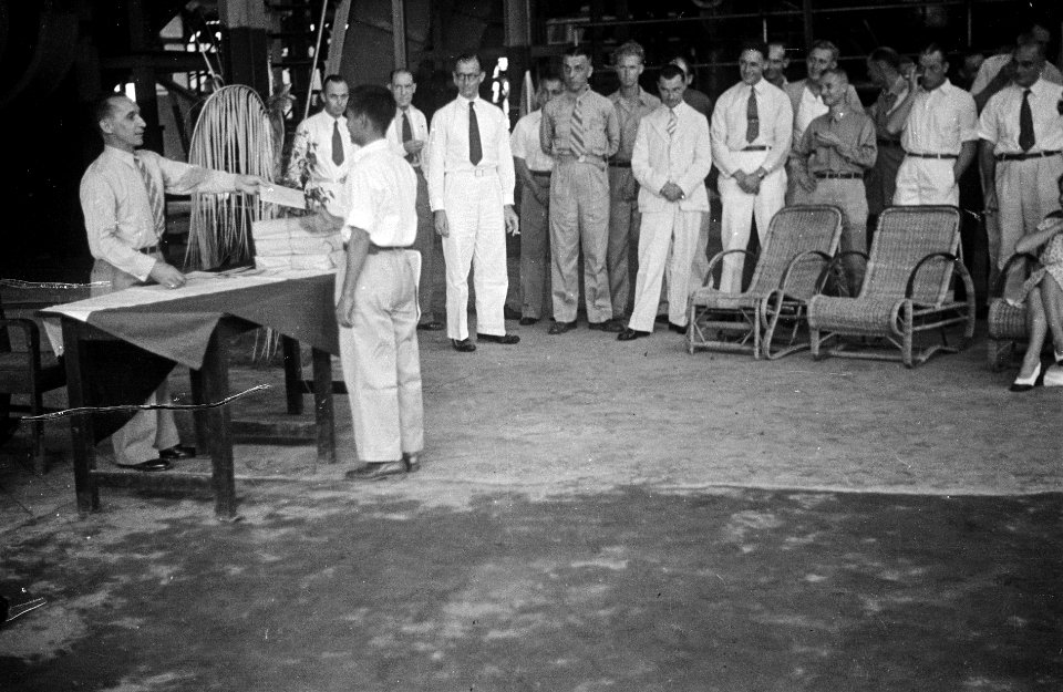Een Indonesische man krijgt iets uitgereikt (een diploma) van een man in unifor, Bestanddeelnr 7093