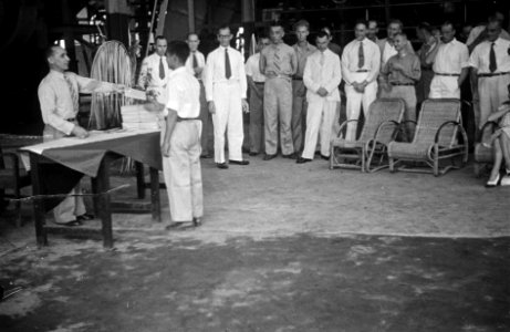 Een Indonesische man krijgt iets uitgereikt (een diploma) van een man in unifor, Bestanddeelnr 7093