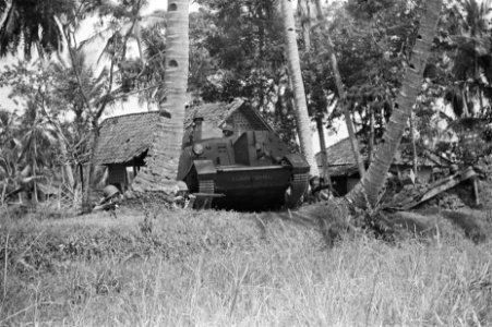 Een brencarrier genaamd Zwarte Duivel manoeuvreert in een kampong, terwijl aa, Bestanddeelnr 62-1-3