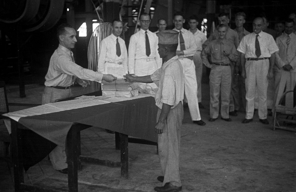 Een Indonesische man met muts krijgt iets uitgereikt (een diploma) van een man , Bestanddeelnr 7097