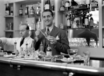 Ex-bokser George Carpentier achter de bar van zijn café, Bestanddeelnr 191-0395