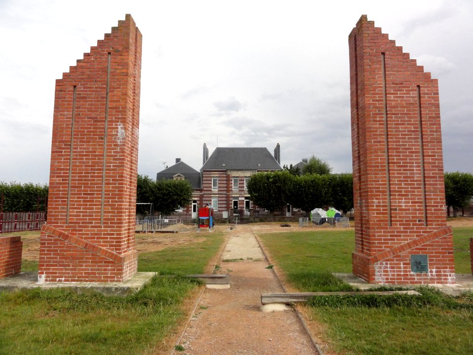 Fauville-en-Caux (Seine-Mar.) mur de noms d'écoliers avec les écoles communales au fond