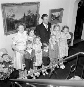 Fabrieksdirecteur Albert van Abbe poserend met groep kinderen tegen een wand met, Bestanddeelnr 255-8492
