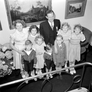 Fabrieksdirecteur Albert van Abbe poserend met groep kinderen tegen een wand met, Bestanddeelnr 255-8491