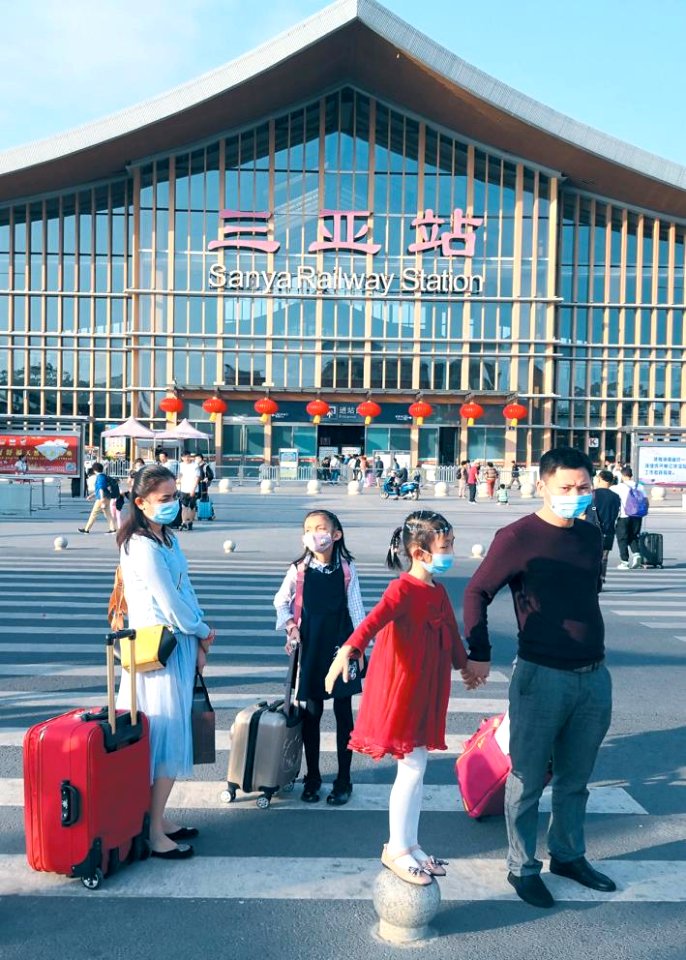 Family wearing masks traveling in Sanya Railway Station