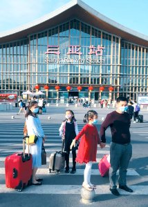 Family wearing masks traveling in Sanya Railway Station