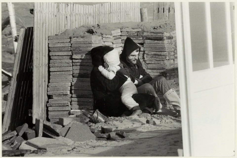 Familie schuilt voor de harde wind op het strand van Zandvoort., NL-HlmNHA 54023385 2