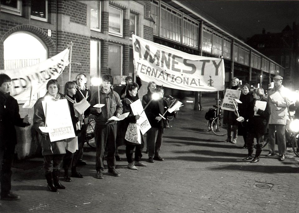 Fakkeldemonstratie op het Stationsplein door Amnesty International afdeling Haarlem. Aangekocht in 1985 van United Photos de Boer bv. - Negatiefnummer 24715 k 6. - Gepubliceerd in het Haarle, NL-HlmNHA 54016572