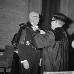 Eredoctoraten in Tilburg, de secretaris van de hogeschool doet de stola om de sc, Bestanddeelnr 914-5117