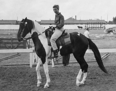 Eva Ring riding Paint horse on race track