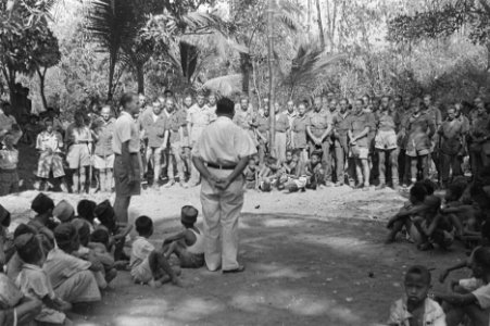 Europese en Indonesische man spreken Nederlandse militairen toe. Op de grond zit, Bestanddeelnr 51-2-1