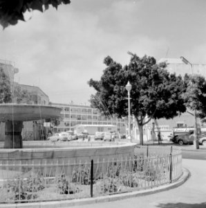 Fontein op plein met gebouwen, auto's en bomen op de achtergrond, Bestanddeelnr 255-2981